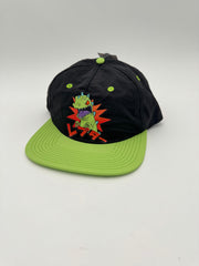Black cap with green brim featuring a cartoon character on a white background
